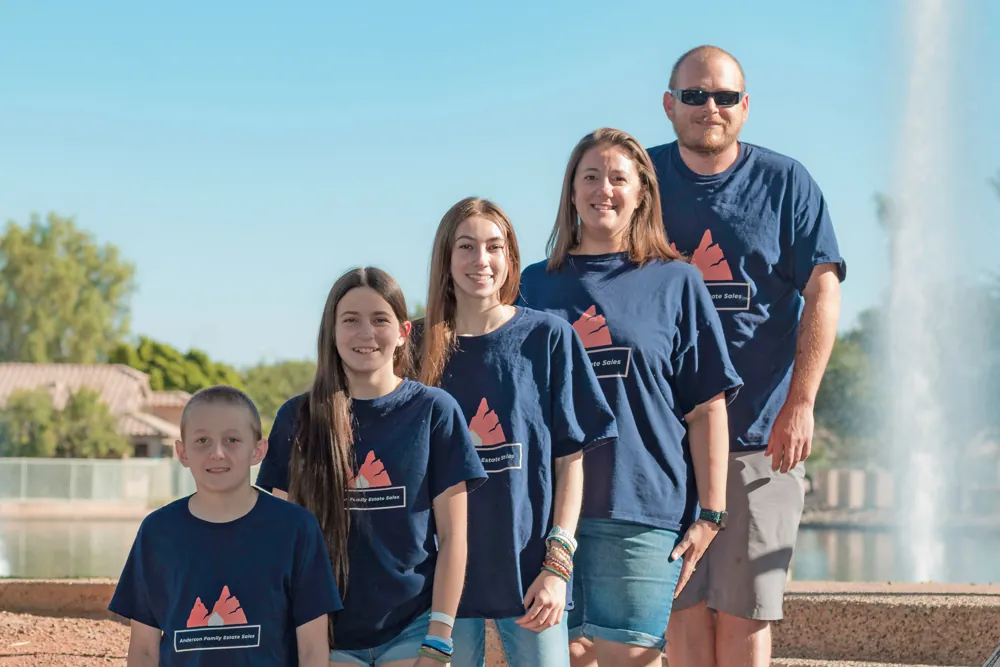 The Anderson family in matching navy company T-shirts, standing in front of a fountain